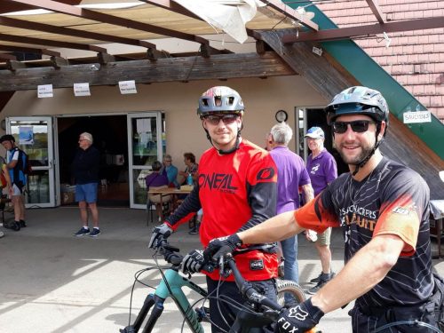 Photographie du Circuit des Myrtilles, deux cyclistes à pieds sourient pour la caméra
