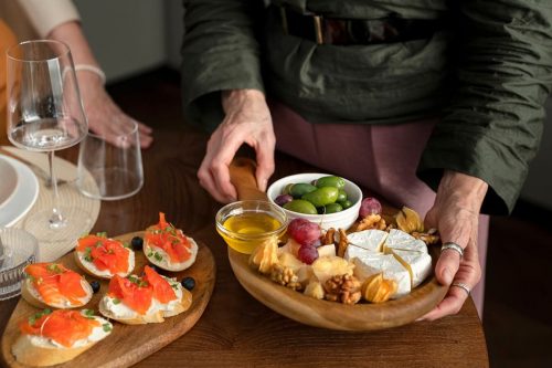 Photographie d'une personne tenant un plateau apéritif avec du fromage et des noix