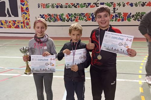 Photographie de trois enfants avec diplômes, médailles et trophées d'éducation routière à vélo