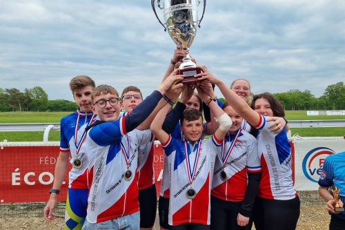 Photographie d'un groupe d'enfants portant tous ensemble un gros trophée