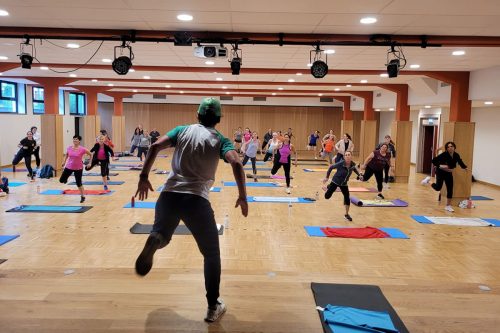 Photographie du groupe de l'activité Fit Training en train de réaliser des sauts d'une jambe à l'autre