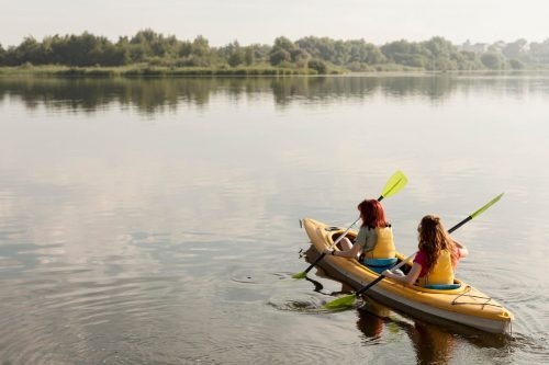 Photographie de deux femmes en train de ramer dans un canoë kayak