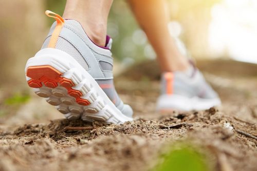 Photographie d'une femme en train de marcher, gros plan sur ces chaussures de sport