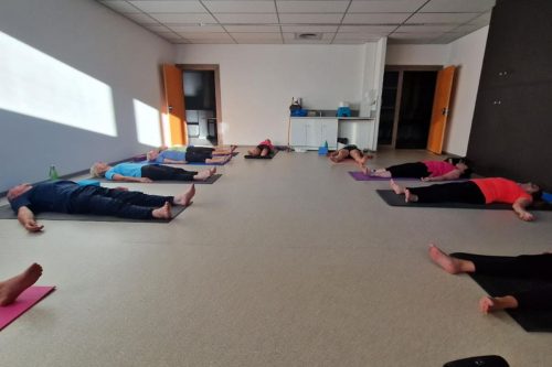 Photographie d'un groupe pendant l'activité Yoga allongés sur le dos sur des tapis de yoga