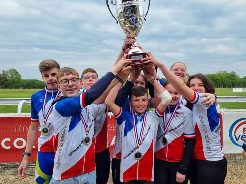 Photographie d'un groupe d'enfants portant tous ensemble un gros trophée